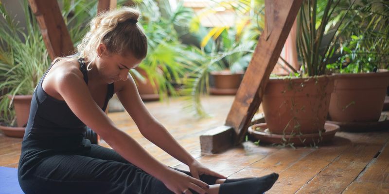 A calm and inviting empty yoga mat on a wooden floor.